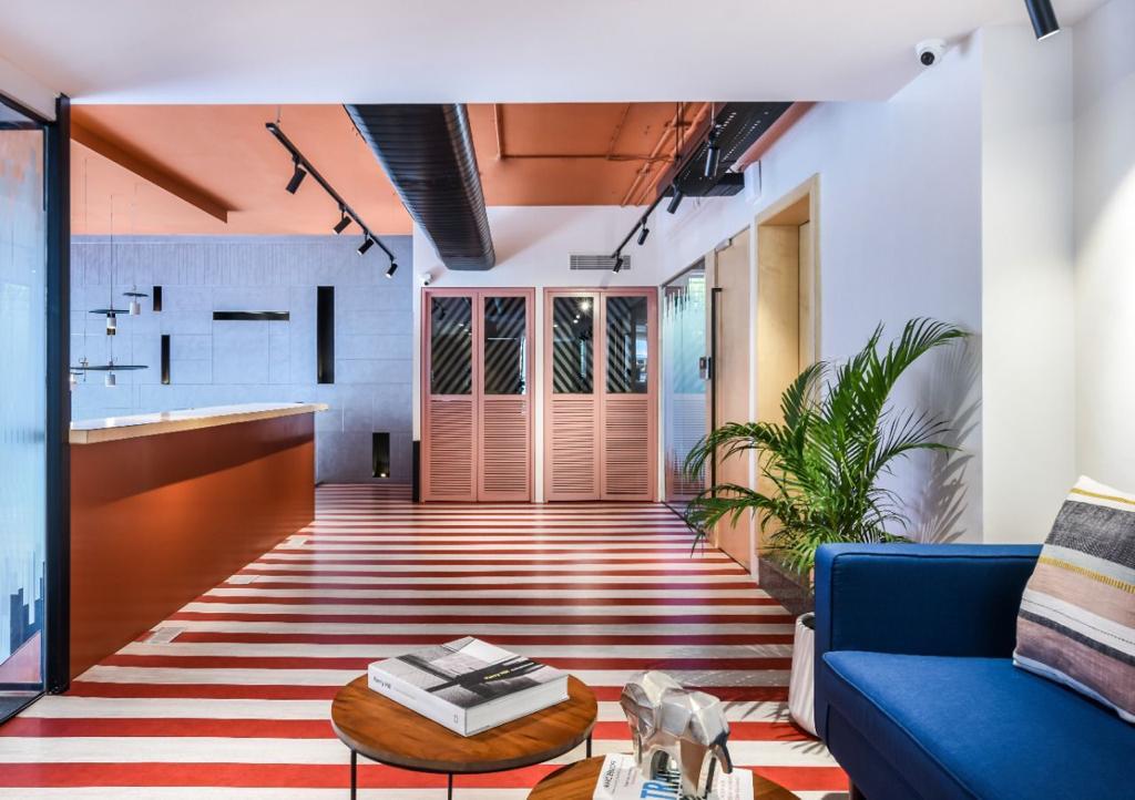 Venus Community Corridor — Bold striped floors with copper accents