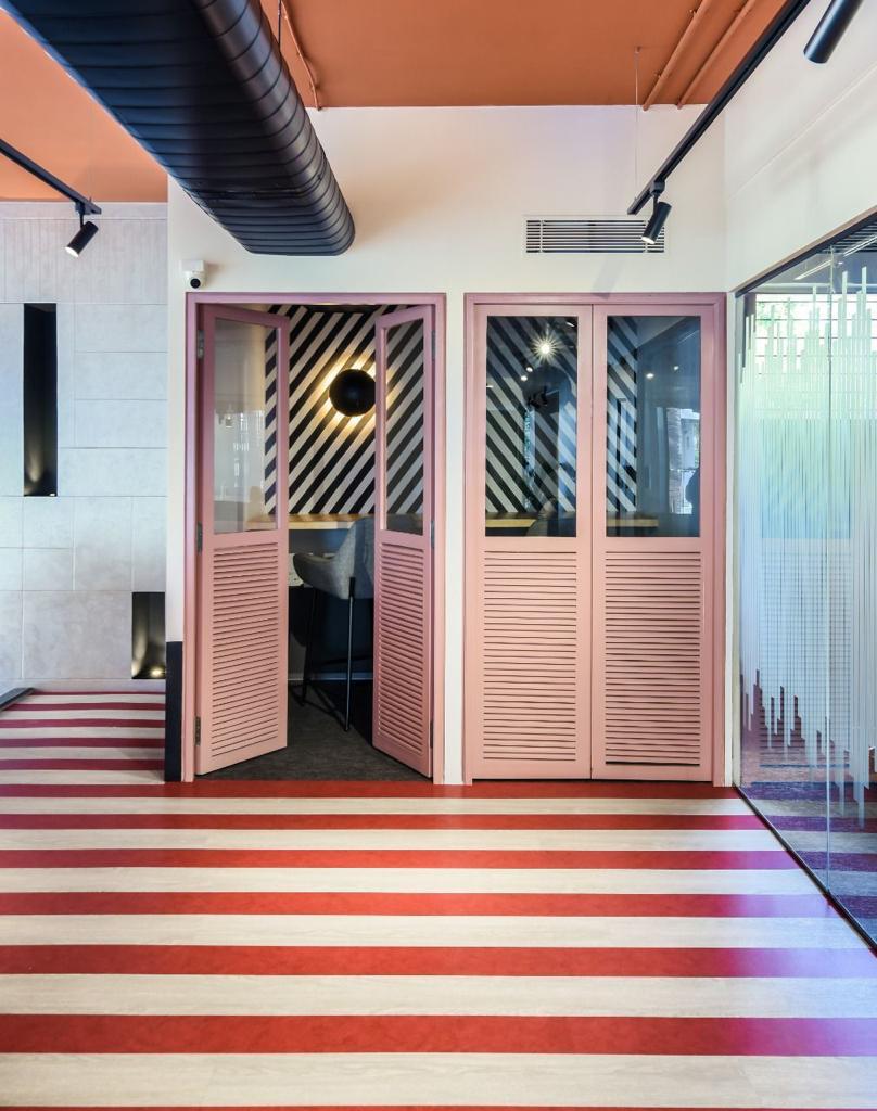 Venus Community Meeting Pods — Pink louvered doors with striped flooring