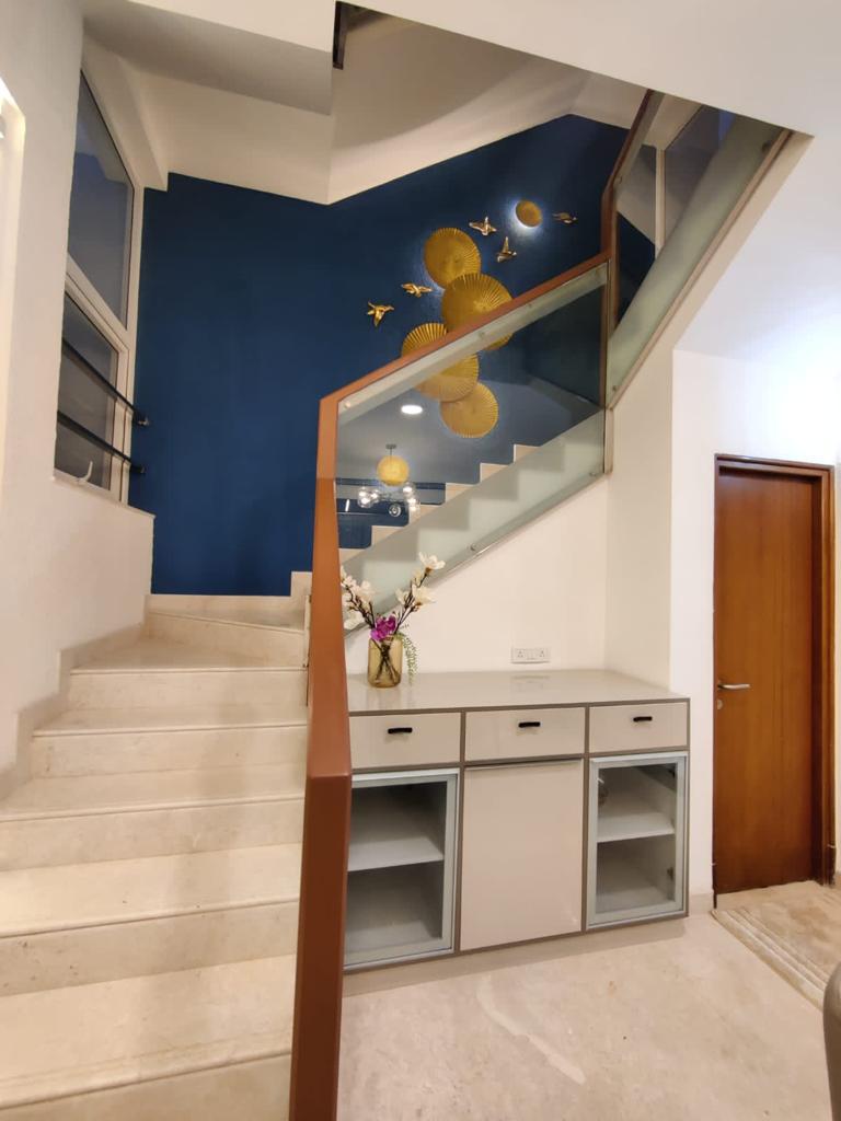 Statement staircase with glass railing and gold wall art