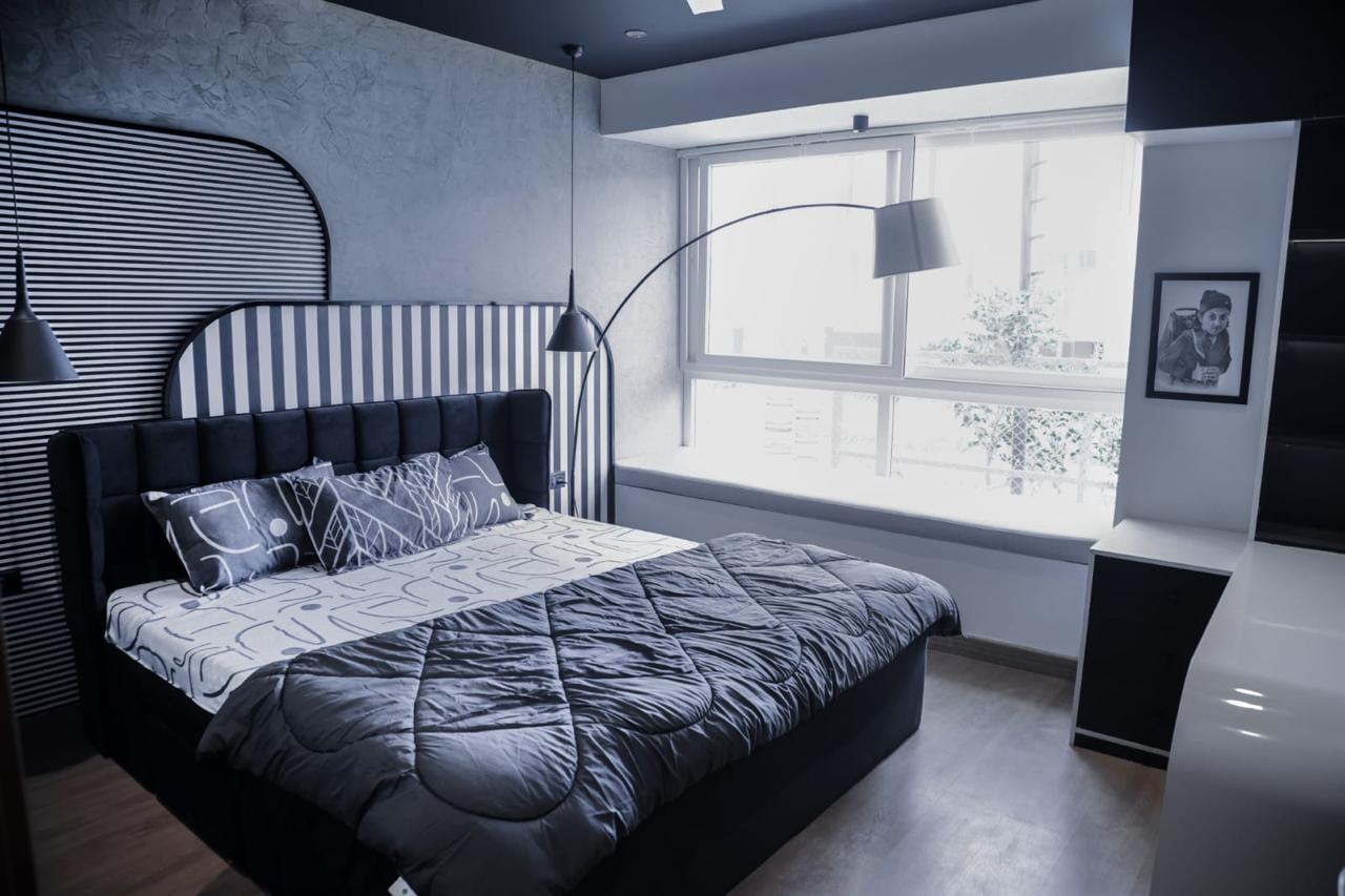 Monochrome bedroom with striped headboard and arc lamp