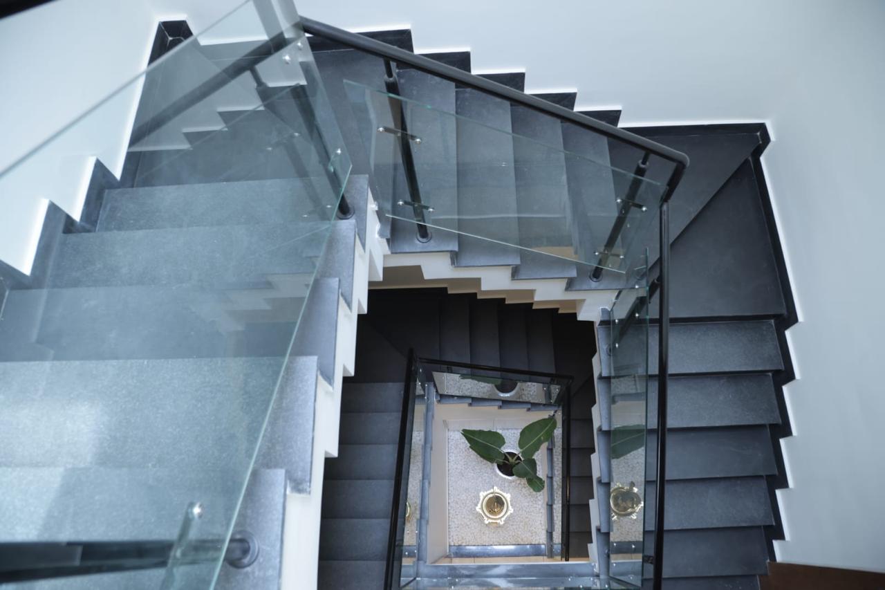 Architectural spiral staircase with glass railing and indoor plant